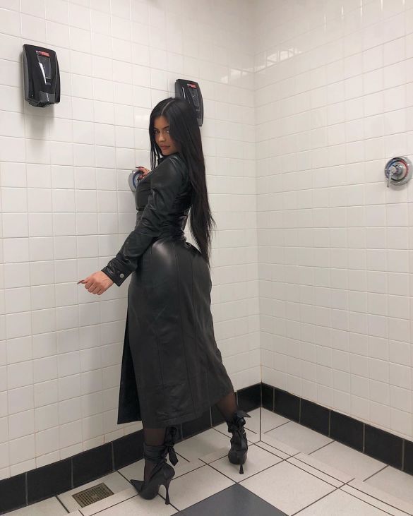 Kylie Jenner poses in the shower in a leather dress and stilettos