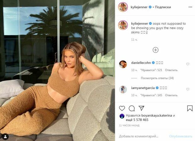 Kylie Jenner bends over in a seductive pose on the couch