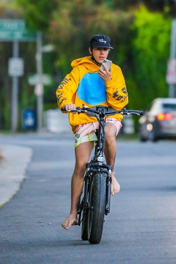 Justin Bieber rides barefoot on a bicycle